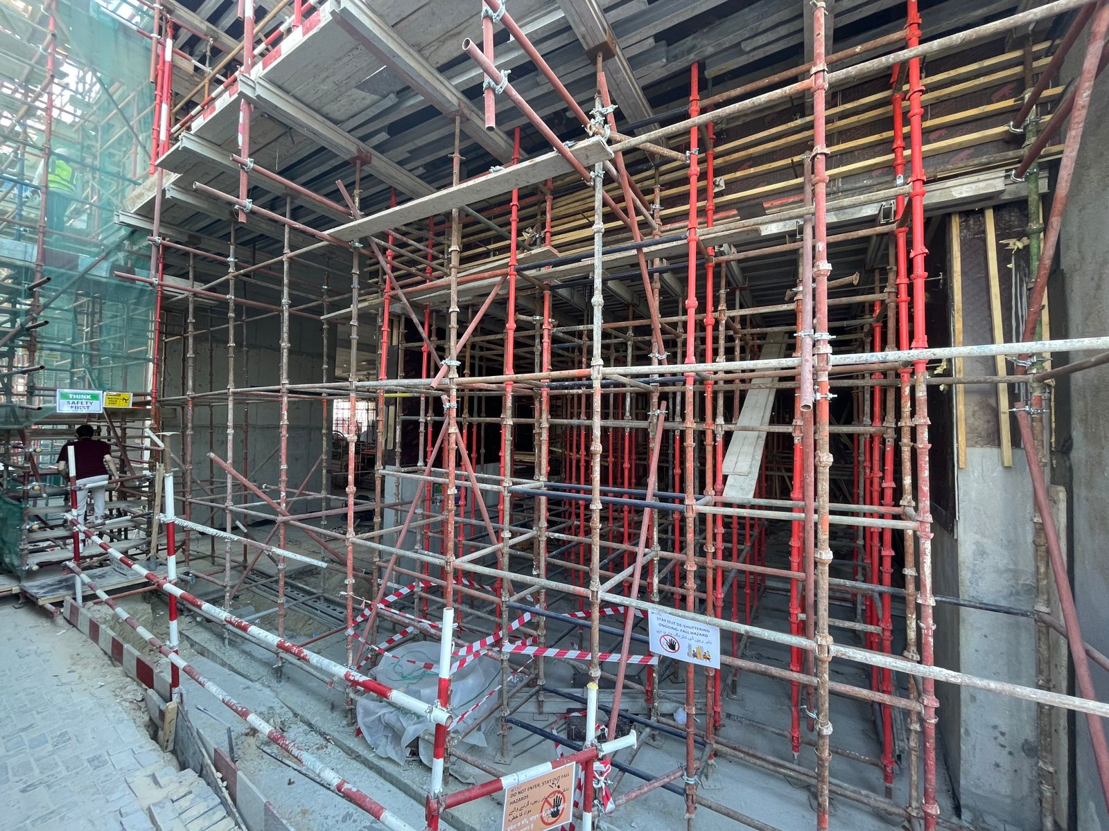 Pearl House By Imtiaz Construction site featuring scaffolding with red and white barriers, indicating ongoing building work.